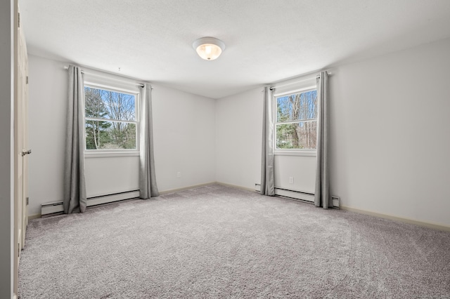 unfurnished room with plenty of natural light, light carpet, and baseboard heating