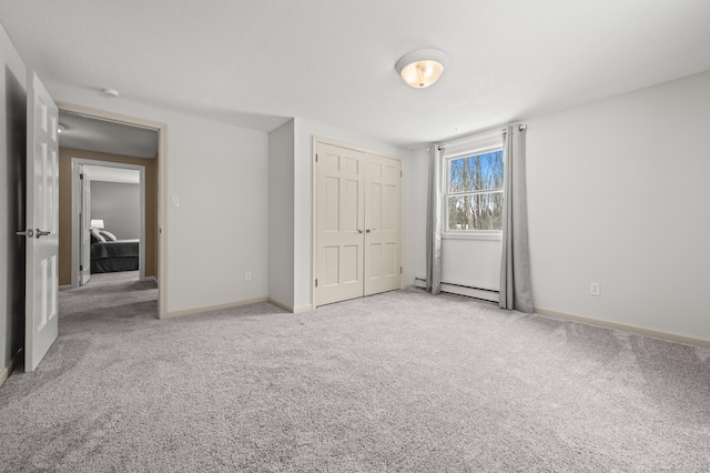 unfurnished bedroom featuring light carpet, a baseboard radiator, and a closet