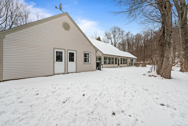 view of snow covered rear of property