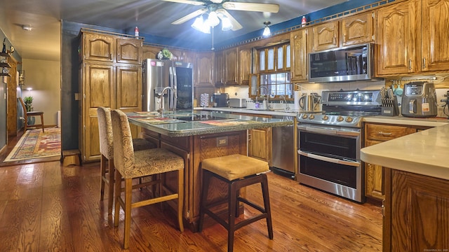 49 Quinebaug Ave, Putnam, CT 06260 - kitchen with appliances with stainless steel finishes, dark wood-type flooring, ceiling fan, and brown cabinetry