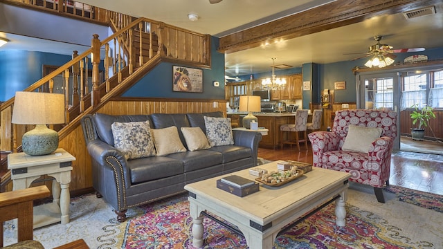 49 Quinebaug Ave, Putnam, CT 06260 - living room featuring wainscoting, a ceiling fan, stairs, a chandelier, and beam ceiling