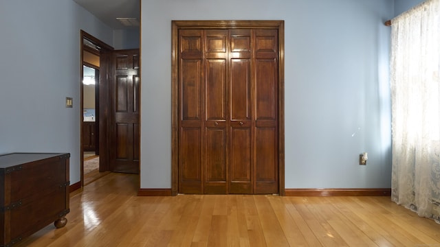 49 Quinebaug Ave, Putnam, CT 06260 - unfurnished bedroom with light wood-type flooring, baseboards, and a closet
