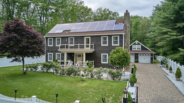 49 Quinebaug Ave, Putnam, CT 06260 - colonial home featuring a balcony, roof mounted solar panels, and a chimney