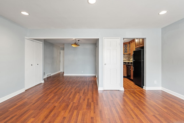 unfurnished room with recessed lighting, dark wood-style flooring, and baseboards