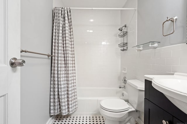 bathroom with toilet, shower / tub combo, tile walls, and vanity