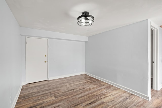 unfurnished room with baseboards and wood finished floors