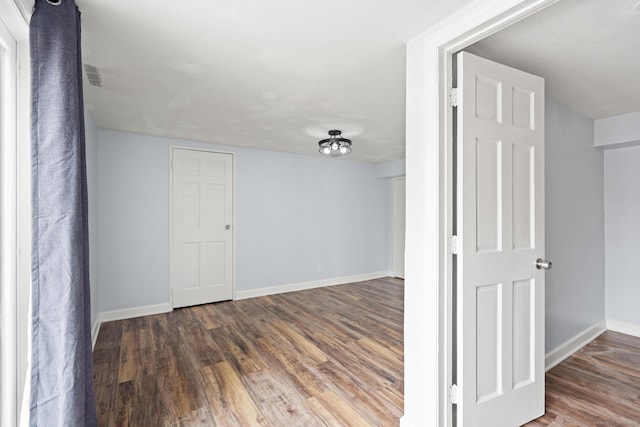 spare room with visible vents, baseboards, and wood finished floors