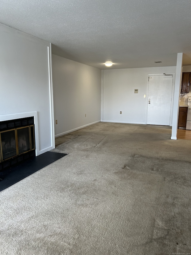 unfurnished living room featuring dark carpet and a textured ceiling