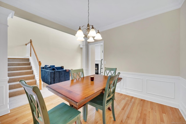 dining room featuring crown molding, light hardwood / wood-style flooring, and a chandelier