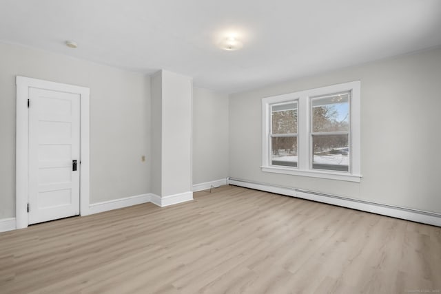 empty room featuring a baseboard radiator and light wood-type flooring