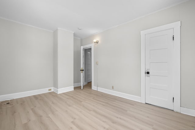 spare room featuring ornamental molding and light hardwood / wood-style floors