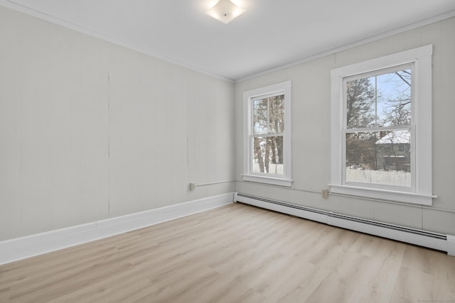 unfurnished room with ornamental molding, a wealth of natural light, light hardwood / wood-style floors, and baseboard heating