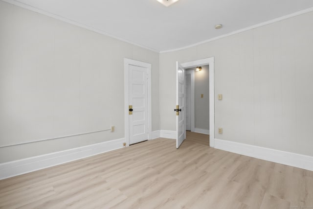 spare room featuring crown molding and light wood-type flooring