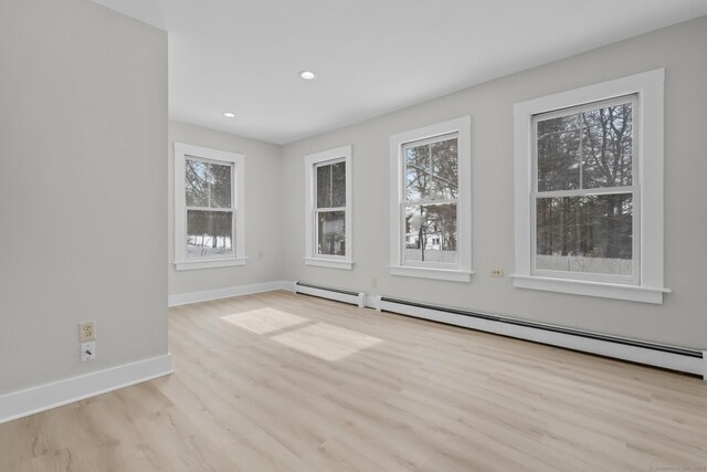 empty room featuring light hardwood / wood-style flooring and a baseboard radiator