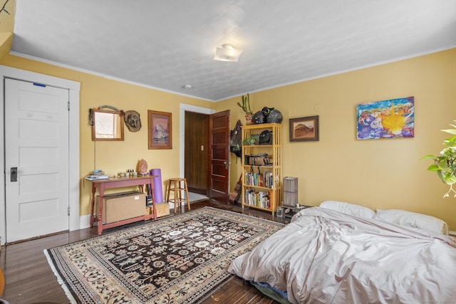 bedroom with dark hardwood / wood-style flooring and crown molding