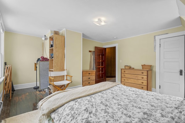 bedroom with crown molding and dark hardwood / wood-style flooring