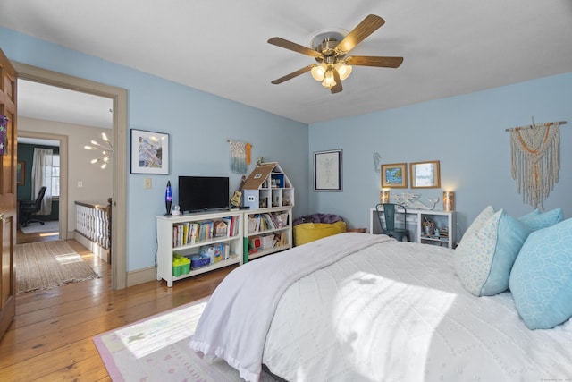 bedroom featuring ceiling fan, baseboards, and wood finished floors