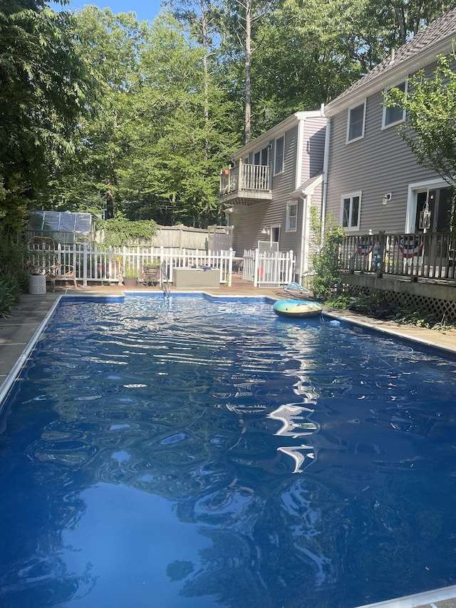 view of pool with a wooden deck, fence, and a fenced in pool