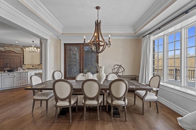 dining area with a chandelier, a tray ceiling, and dark wood-style flooring