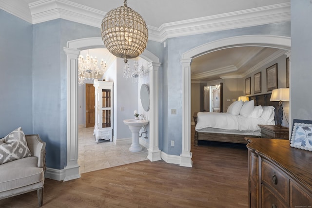 131 Burr Hill Rd, Killingworth, CT 06419 - bedroom featuring decorative columns, arched walkways, wood finished floors, an inviting chandelier, and ornamental molding