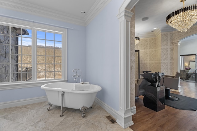 bathroom featuring crown molding, a freestanding tub, visible vents, and decorative columns