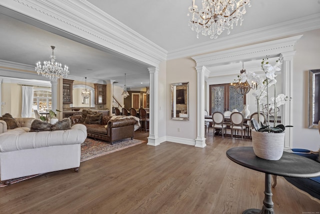 living area with dark wood-style floors, decorative columns, a chandelier, and crown molding