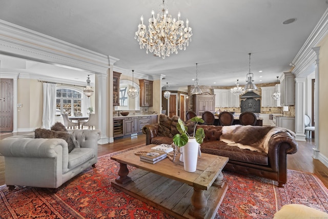 living area with beverage cooler, dark wood-type flooring, an inviting chandelier, and crown molding