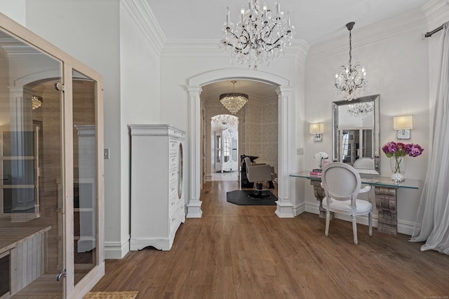 interior space featuring an inviting chandelier, arched walkways, wood finished floors, and ornamental molding