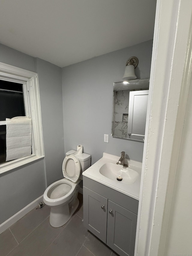 half bath featuring toilet, baseboards, vanity, and tile patterned floors