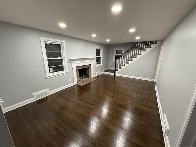 unfurnished living room featuring dark wood-style floors, stairway, visible vents, and recessed lighting