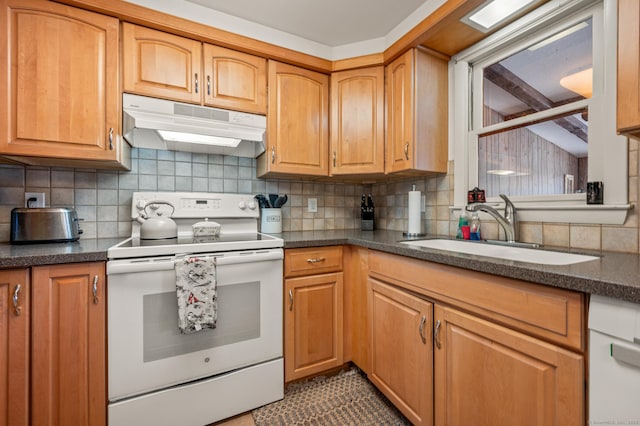 kitchen featuring electric stove, dark countertops, a sink, and under cabinet range hood