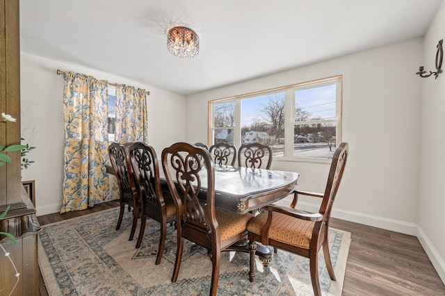 dining room featuring dark wood-type flooring and baseboards