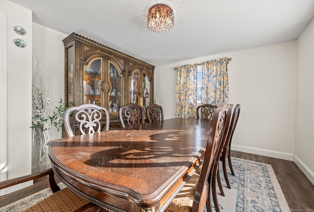 dining space featuring dark wood finished floors and baseboards