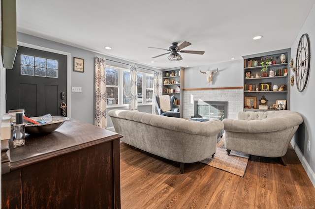 living room with recessed lighting, a brick fireplace, ceiling fan, and wood finished floors