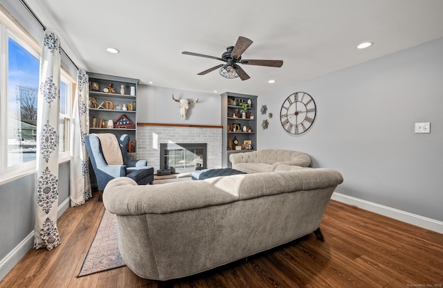 living room featuring dark wood-style flooring, a fireplace, recessed lighting, ceiling fan, and baseboards