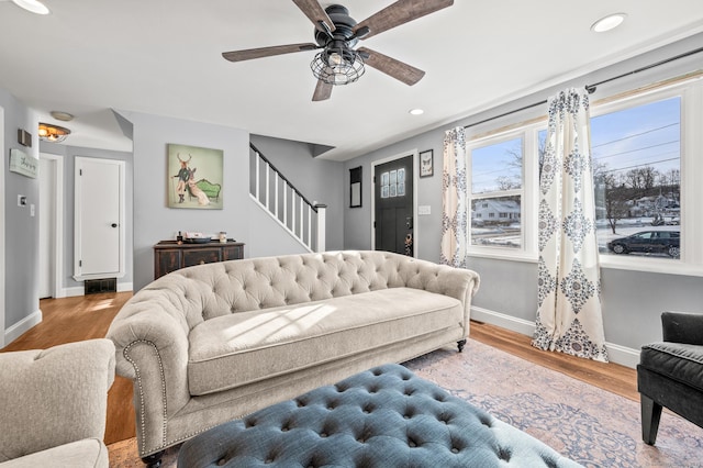 living room featuring visible vents, stairway, light wood-style flooring, and baseboards