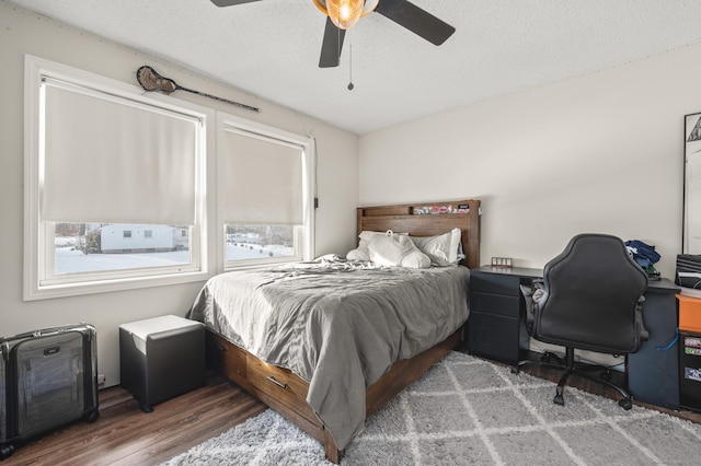 bedroom with a textured ceiling, dark wood finished floors, and a ceiling fan