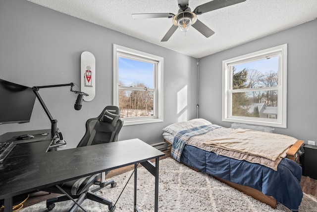 bedroom featuring ceiling fan, a textured ceiling, and wood finished floors