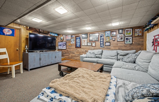 carpeted living room featuring wood walls