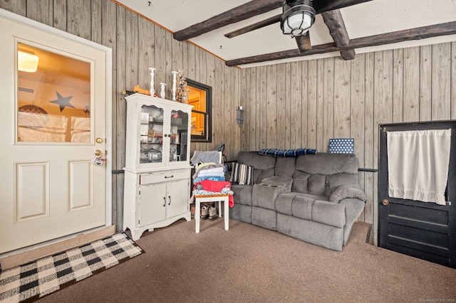 living room with beam ceiling, carpet flooring, ceiling fan, and wooden walls