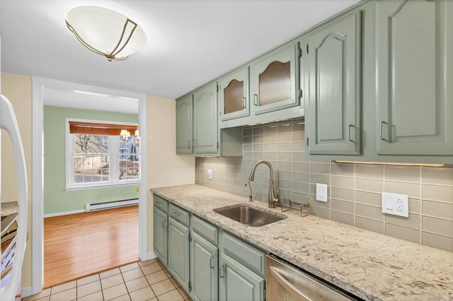 kitchen featuring sink, backsplash, light stone counters, light tile patterned floors, and a baseboard radiator