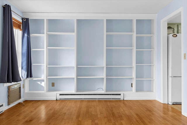 closet with a wall unit AC and a baseboard heating unit