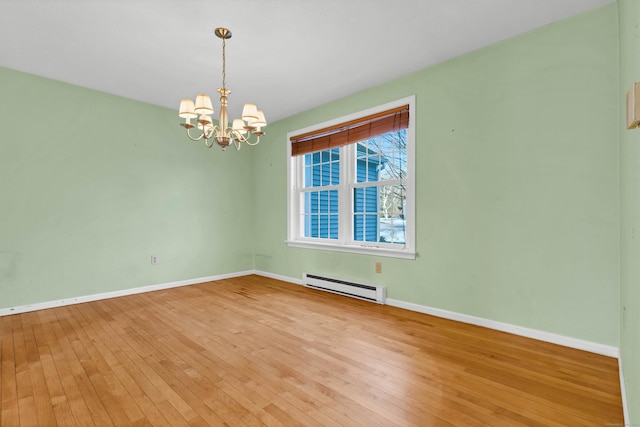 unfurnished room with hardwood / wood-style flooring, a chandelier, and a baseboard heating unit