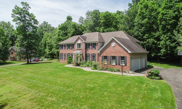 colonial home featuring a garage and a front yard