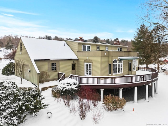 snow covered house featuring a deck