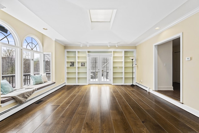 empty room with a skylight, french doors, dark wood finished floors, and baseboard heating