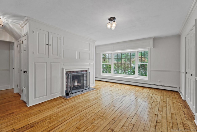 unfurnished living room with light wood-style floors, a brick fireplace, ornamental molding, and baseboard heating