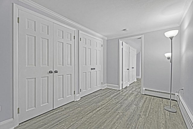 unfurnished bedroom with baseboards, multiple closets, light wood-type flooring, and crown molding