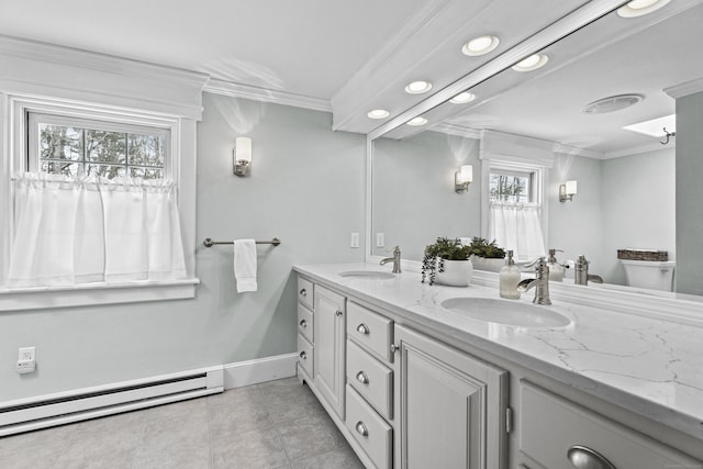 bathroom with a baseboard heating unit, a sink, and ornamental molding