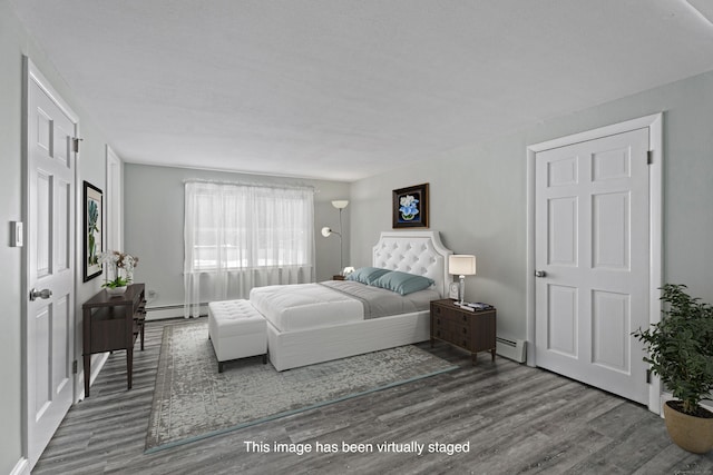 bedroom featuring a baseboard heating unit and wood finished floors